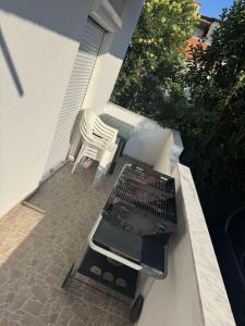 a barbecue grill and a chair on a patio at Σουίτα Αλέξανδρος in Pefkochori