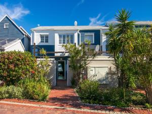 a white house with a blue at KnysnaQuays 4 in Knysna +19 photos
