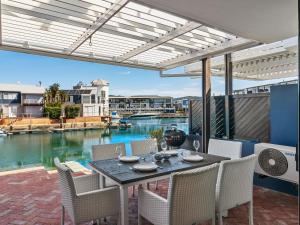 a patio with a table and chairs with a view of the water at KnysnaQuays 4 in Knysna