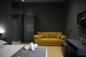 a living room with a yellow couch and a refrigerator at Hotel Bel Ami Tirana in Tirana
