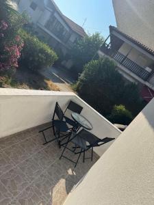 a patio with two chairs and a table on a balcony at Σουίτα Αλέξανδρος in Pefkochori