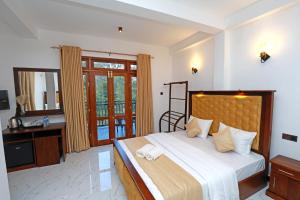 a bedroom with a large bed and a mirror at Zephyra Ella in Ella