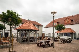 a gazebo with tables and chairs in a courtyard at Landhotel Sonnenhof in Ossig