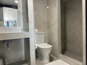a white bathroom with a toilet and a shower at Evita Dream Hotel in Marmari