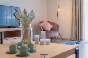 a living room with a table with a vase of flowers at Thyline One - new spacious apartment for 8 persons in Nieuwpoort
