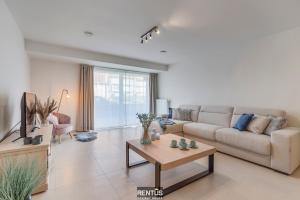 a living room with a couch and a table at Thyline One - new spacious apartment for 8 persons in Nieuwpoort