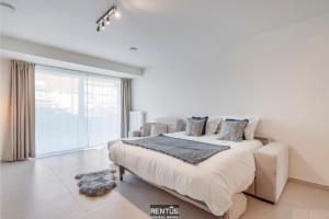 a bedroom with a bed and a large window at Thyline One - new spacious apartment for 8 persons in Nieuwpoort +17 photos