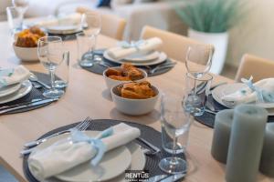 a table with plates of food and wine glasses at Thyline One - new spacious apartment for 8 persons in Nieuwpoort
