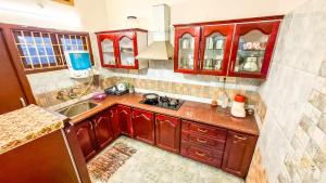 a kitchen with red cabinets and a sink at Radiance Crystal in Pondicherry +11 photos