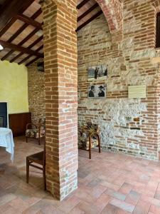 a room with a brick wall and a pillar at La torre del cappellaio in Fabriano