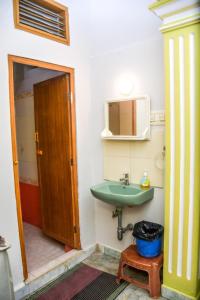 a bathroom with a green sink and a mirror at Radiance Crystal in Pondicherry