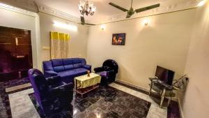 a living room with a blue couch and a tv at Radiance Crystal in Pondicherry