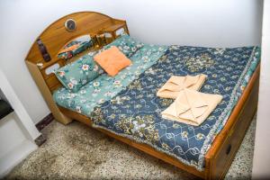 a small bed with a blue bedspread and pillows at Radiance Crystal in Pondicherry