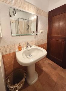 a bathroom with a sink and a mirror and a basket at La torre del cappellaio in Fabriano +21 photos