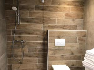 a bathroom with a shower with a wooden wall at hotel de kaaipoort in Aardenburg +33 photos
