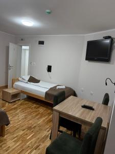 a room with a bed and a table and a tv at Babiko DTM 037 in Čitluk