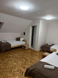 a room with two beds and a wooden floor at Babiko DTM 037 in Čitluk