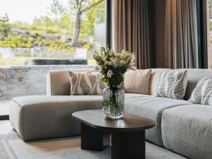 a vase of flowers on a table in a living room at Villa D'Jora in Mikołajki