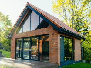 a brick house with large glass windows at Villa D'Jora in Mikołajki
