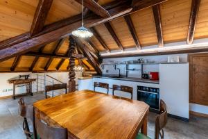 ein Esszimmer mit einem Holztisch und eine Küche in der Unterkunft Corleta 2 in Ovaro