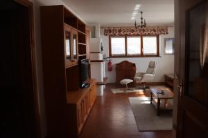 a living room with a television and a couch at Al Roser in Forno di Zoldo