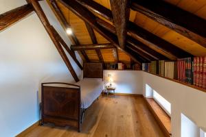 ein Dachzimmer mit einem Bett und einem Bücherregal in der Unterkunft Corleta 2 in Ovaro