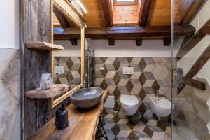 ein Badezimmer mit Waschbecken und zwei Toiletten in der Unterkunft Corleta 2 in Ovaro