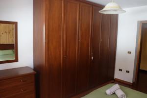 a bedroom with wooden cabinets and a bed and a mirror at Al Roser in Forno di Zoldo