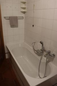 a bath tub with a shower in a bathroom at Al Roser in Forno di Zoldo +7 photos