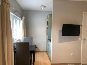 a room with a desk and a television on a wall at hotel de kaaipoort in Aardenburg