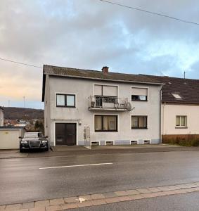 a white house with a car parked in front of it at Selina's Apartment in Oberthal