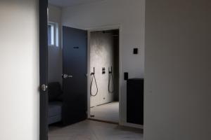 a hallway with a door leading to a bathroom with a shower at Forest Dream House in Naantali +24 photos