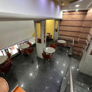a room with tables and chairs and a staircase at Hotel Grand Galaxie in Caracas