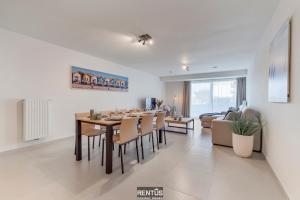a dining room and living room with a table and chairs at Thyline One - new spacious apartment for 8 persons in Nieuwpoort
