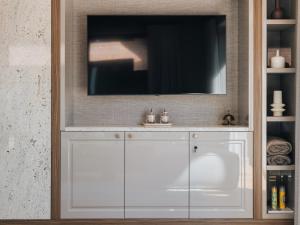 a white cabinet with a television on top of it at Villa D'Jora in Mikołajki
