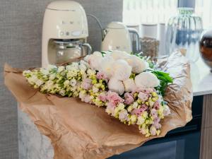 a bouquet of pink and white flowers on a counter at Villa D'Jora in Mikołajki +35 photos