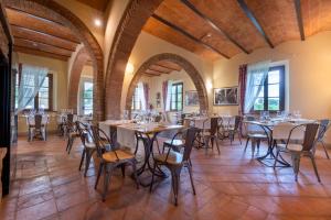 a dining room with tables and chairs and windows at Boccioleto Resort - Place of Charme in Montaione