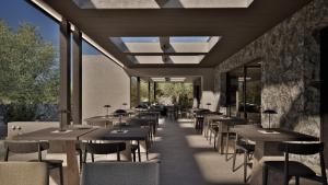 a restaurant with tables and chairs and windows at Neme Slow Living Retreat in Rethymno