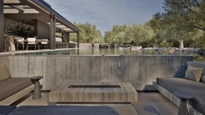 a swimming pool with a table and a house at Neme Slow Living Retreat in Rethymno