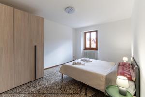 a bedroom with a bed and a wooden cabinet at La Cort di Vigje 2 in Ovaro