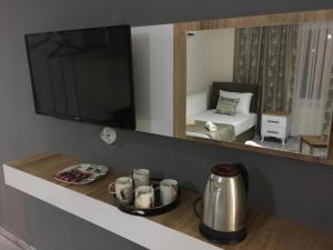 a living room with a television and a table with a tea kettle at Sun Rose Pansiyon in Pamukkale