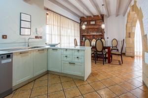 a kitchen with a sink and a table with chairs at Luxury Villa Esmeralda in Suances