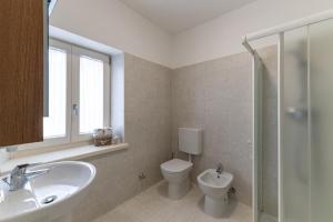 a bathroom with a toilet and a sink and a shower at La Cort di Vigje 2 in Ovaro