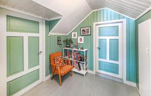 a room with green walls and a chair and a book shelf at 4 Bedroom Awesome Home In Ulefoss in Ulefoss +12 photos
