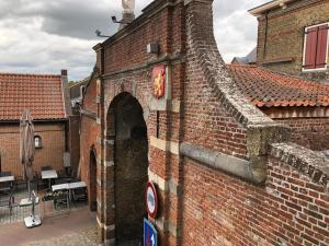 a brick building with an arch in the side of it at hotel de kaaipoort in Aardenburg