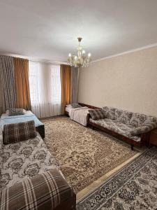 a living room with two beds and a couch at Guesthouse Chon - Kemin in Shabdan