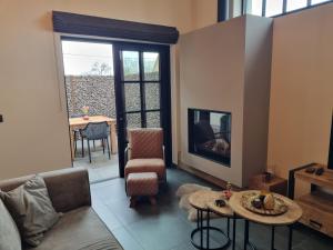 a living room with a couch and a fireplace at Welldone Resort / Cozy Wine in Nieuwerkerken