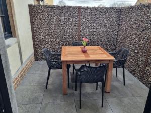 a wooden table with chairs and a vase of flowers on it at Welldone Resort / Cozy Wine in Nieuwerkerken