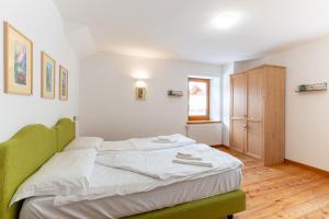 una camera da letto con un letto verde in una stanza di Alpedale a Ovaro Altre 3 foto