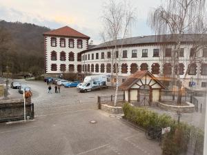 a large building with cars parked in a parking lot at Pension am Schloss in Meiningen